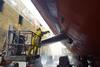 Worker washing ship hull at drydock