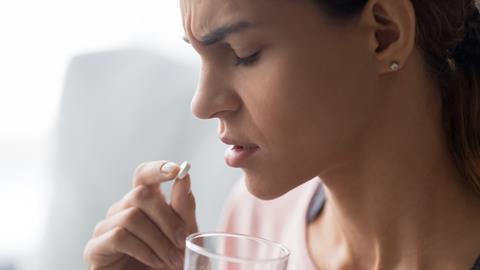 Woman taking a pain killer tablet