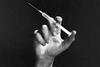 An image showing a hand holding a hypodermic needle