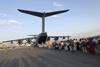 People queuing to board a military plane