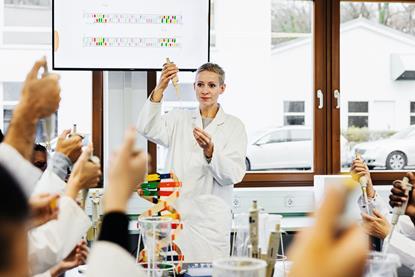 A chemistry teacher instructing university students in practical skills