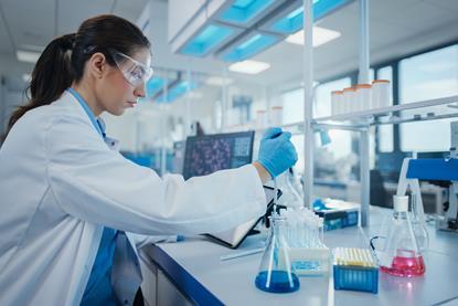 Researcher in lab coat and PPE in the lab