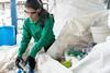 An image showing a woman sorting plastic recycling