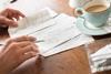 Someone having a cup of tea while doing calculations on a napkin