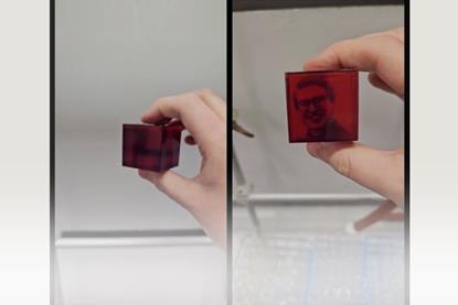 A scientist holds up a 3D display that uses embedded photoswitch molecules contained within a polymer matrix